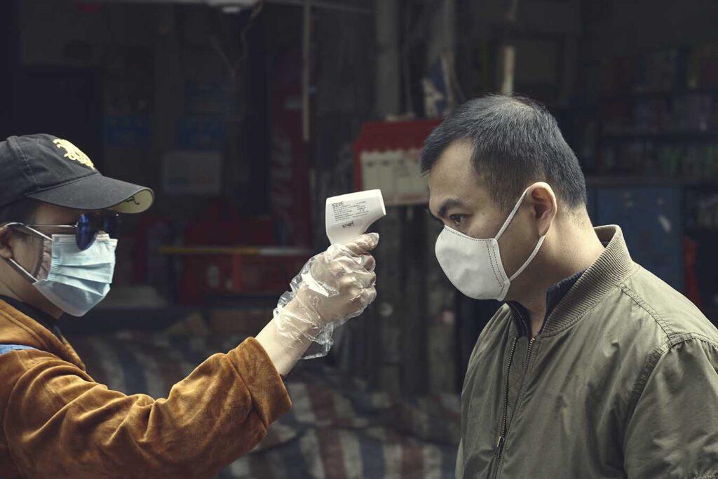 Fotógrafo comercial Madrid - Luis Gómez en China, Control temperatura Fotógrafo comercial Madrid - Luis Gómez en China, Una voluntaria controlando la temperatura de los ciudadanos